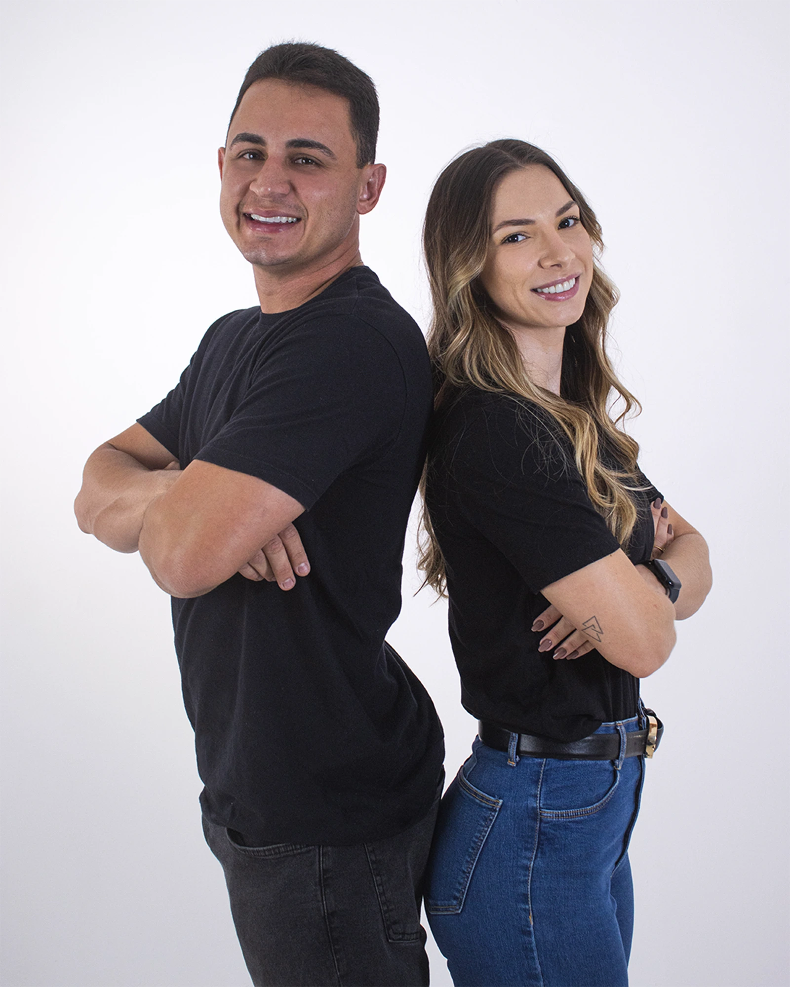 Luiz e Letícia de costas um para o outro, de braços cruzados, com a camiseta da EVA Lab