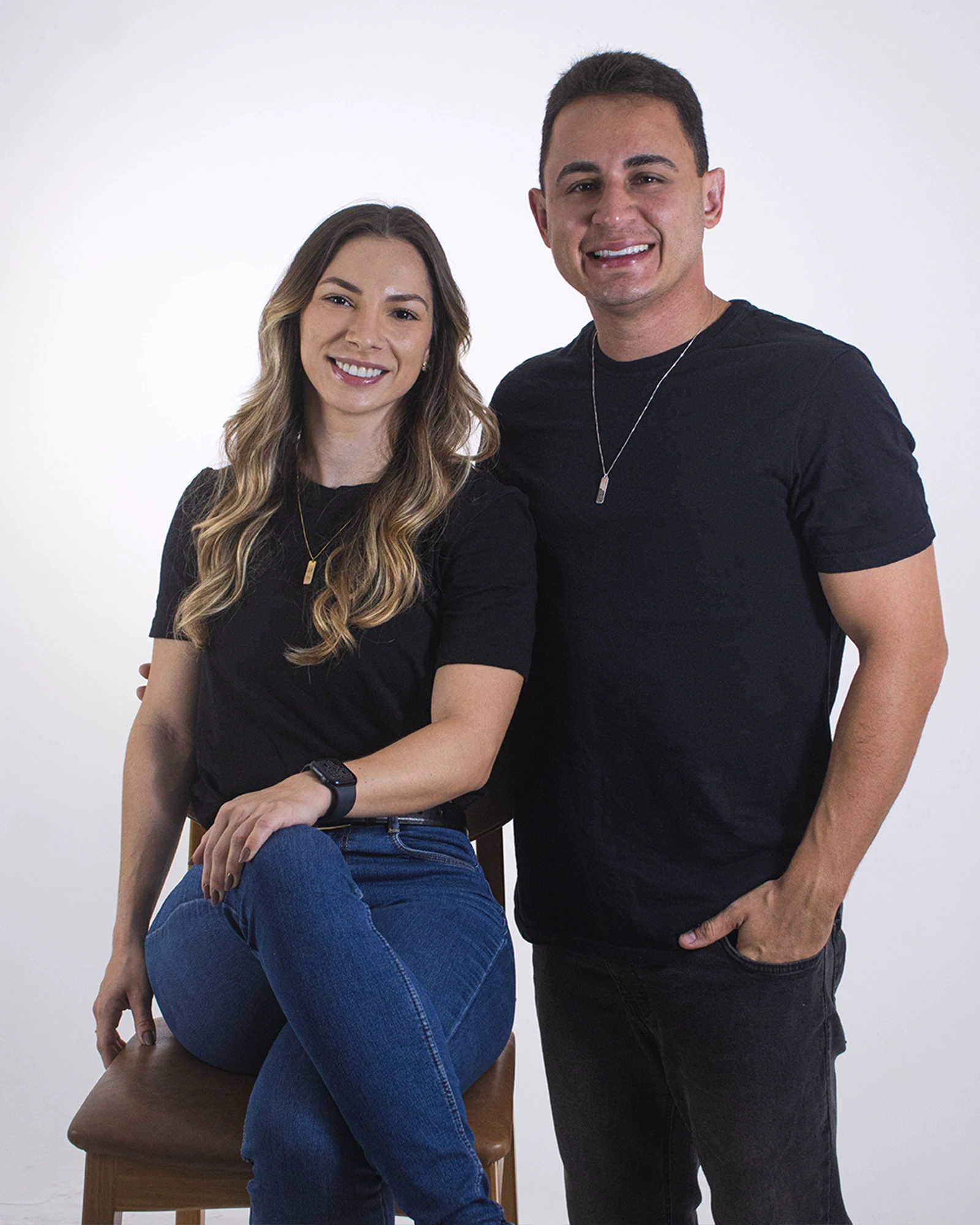 Luiz e Letícia, da EVA Lab, sorrindo em estúdio com a camiseta preta da marca