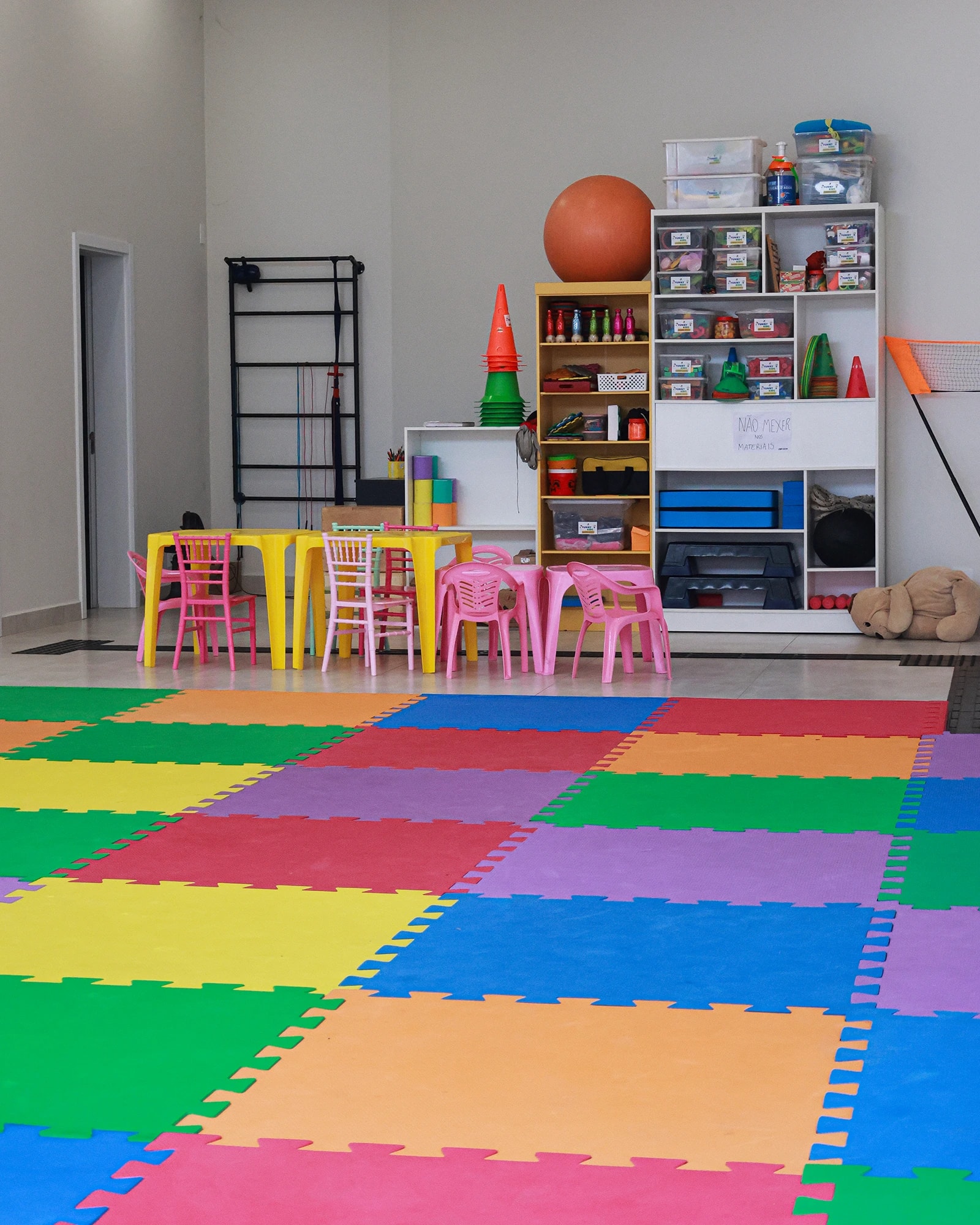 Canto de atividades da Funny Kids, com mesinhas, estante de brinquedos e o piso de EVA