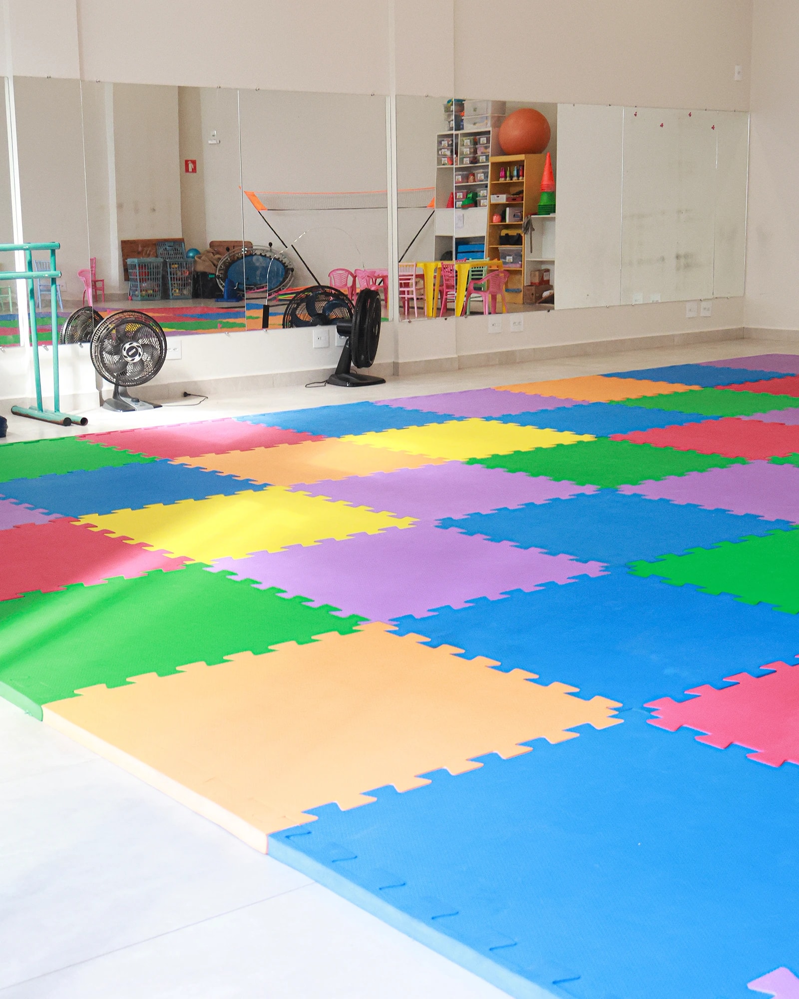 Sala de treino da Funny Kids com placas de EVA coloridas diante da parede de espelhos